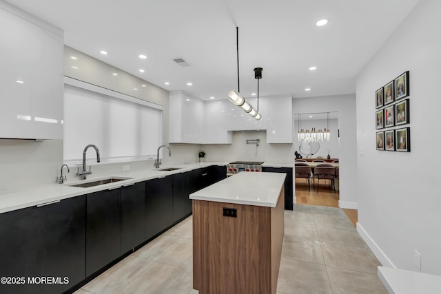 kitchen with modern cabinets, a sink, white cabinetry, dark cabinets, and recessed lighting