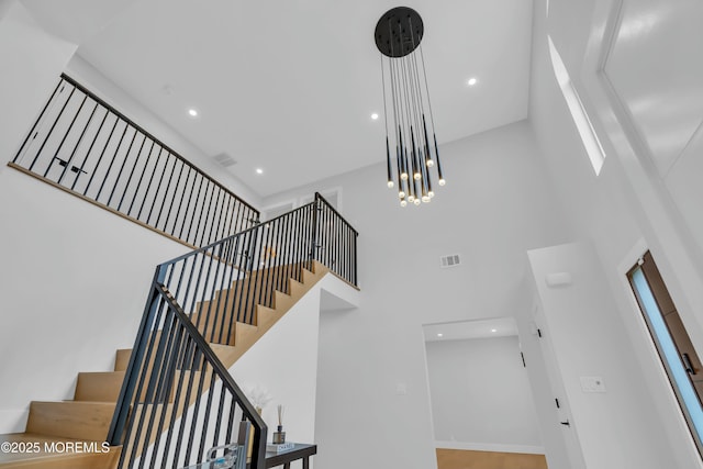 stairs featuring a high ceiling, recessed lighting, and baseboards