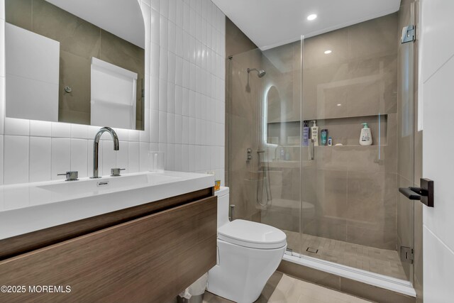 full bathroom with tile walls, toilet, a stall shower, vanity, and recessed lighting