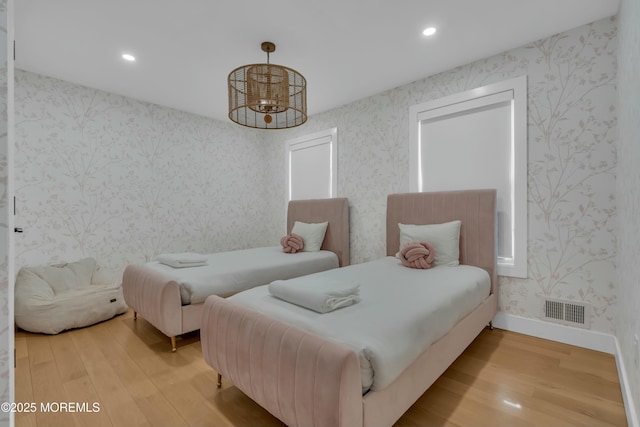 bedroom featuring wallpapered walls, wood finished floors, baseboards, and recessed lighting