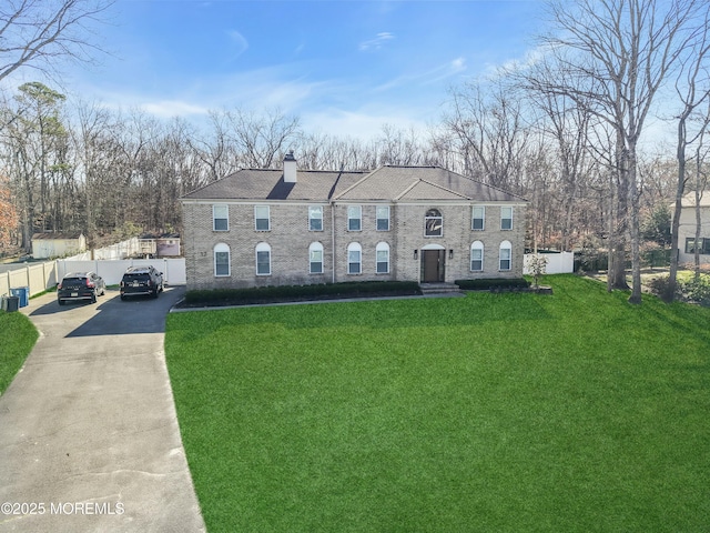 view of front of home with a chimney and driveway