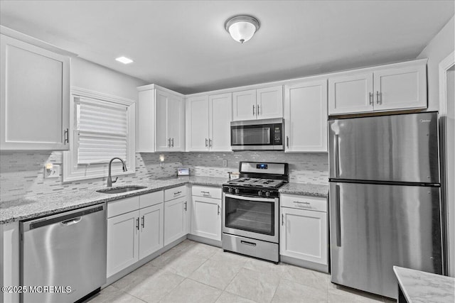 380 Evergreen Dr, Brick, NJ 08723 - kitchen with decorative backsplash, a sink, white cabinets, light stone countertops, and appliances with stainless steel finishes