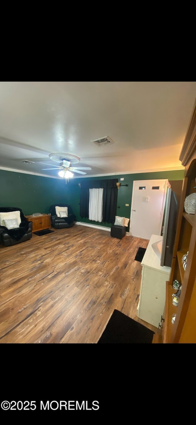 interior space with visible vents, ceiling fan, and wood finished floors