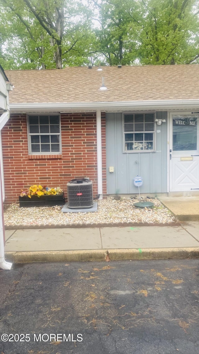 37D Cambridge Ct Unit 100D, Lakewood, NJ 08701 - view of front of house featuring central AC, board and batten siding, and roof with shingles