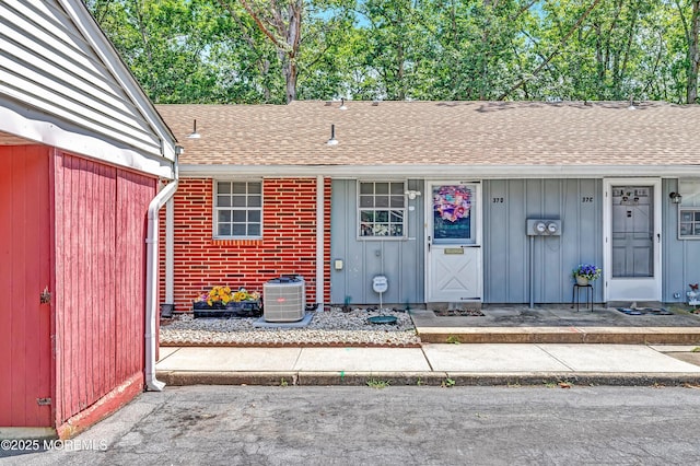 37D Cambridge Ct Unit 100D, Lakewood, NJ 08701 - view of exterior entry with a shingled roof and board and batten siding