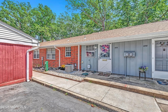 37D Cambridge Ct Unit 100D, Lakewood, NJ 08701 - property entrance featuring board and batten siding, a shingled roof, and brick siding