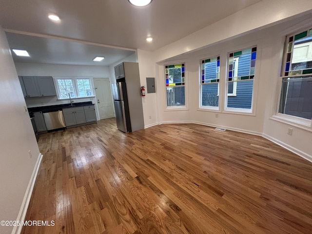 interior space featuring wood finished floors, baseboards, and electric panel
