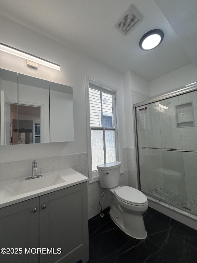 bathroom featuring vanity, toilet, a shower stall, visible vents, and marble finish floor