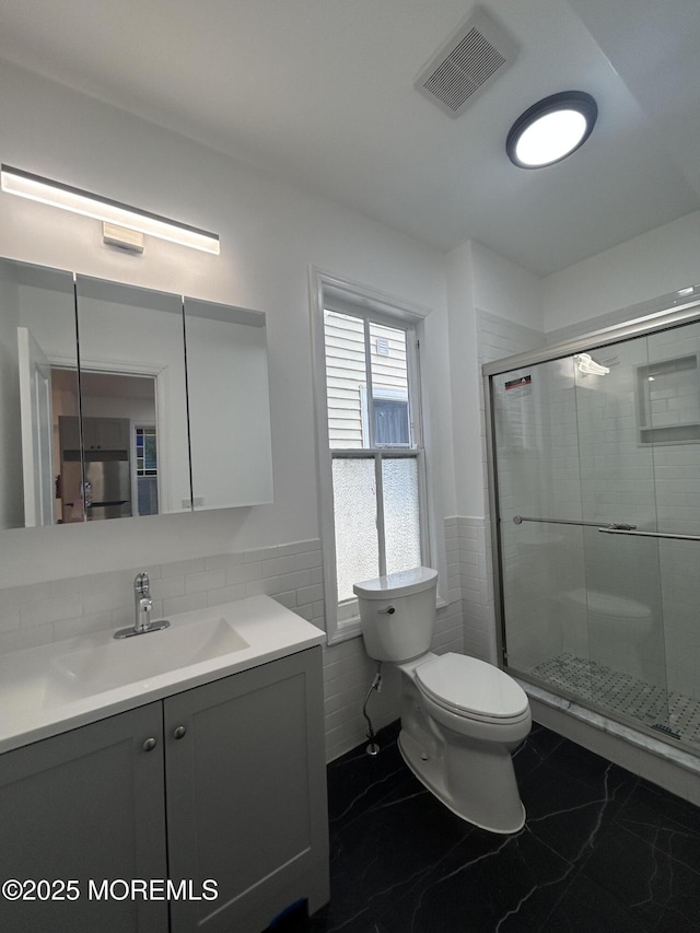 full bath with a shower stall, vanity, visible vents, toilet, and marble finish floor