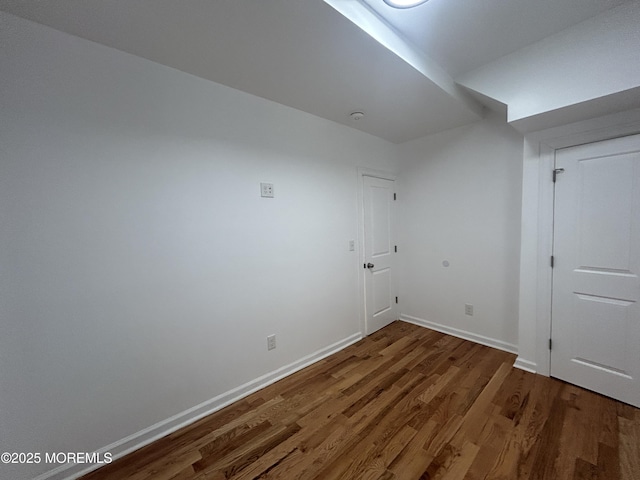 additional living space featuring baseboards and wood finished floors