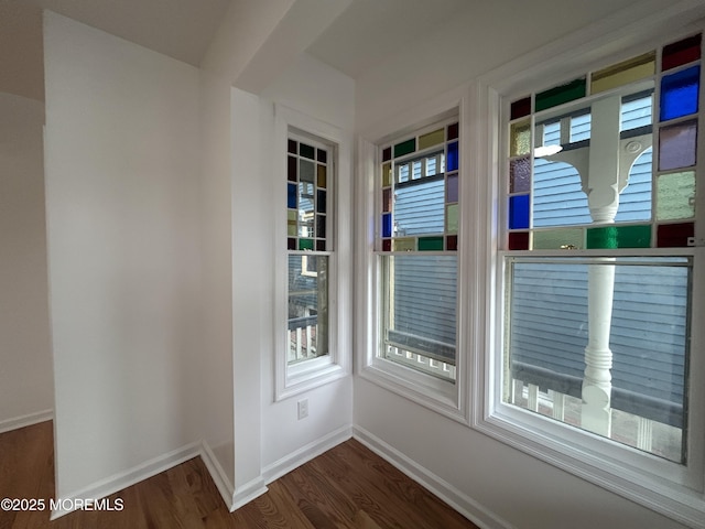 interior space featuring baseboards and dark wood finished floors