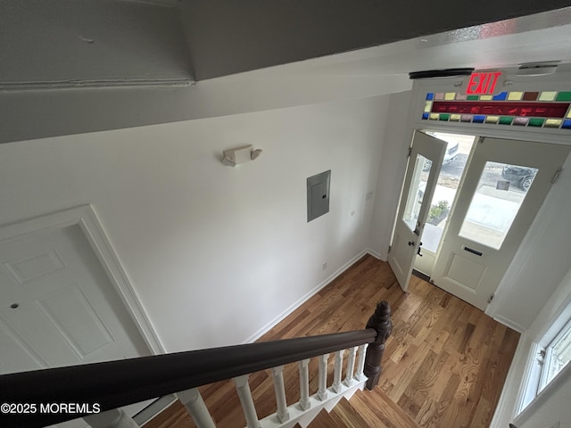 foyer featuring wood finished floors, baseboards, and electric panel