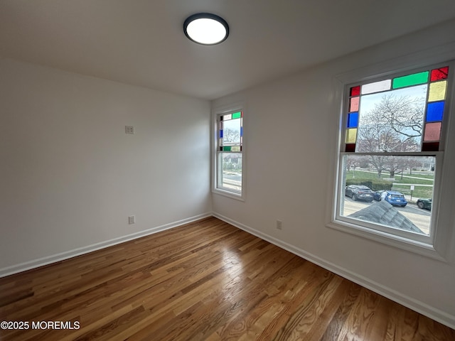 unfurnished room featuring baseboards and wood finished floors