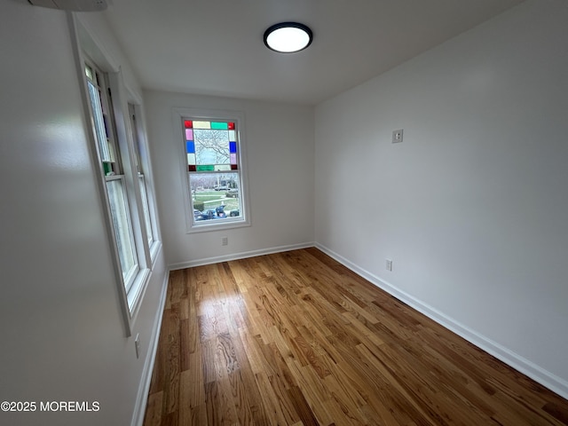 spare room featuring baseboards and wood finished floors