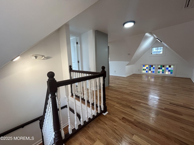 bonus room with wood finished floors, baseboards, vaulted ceiling, and visible vents