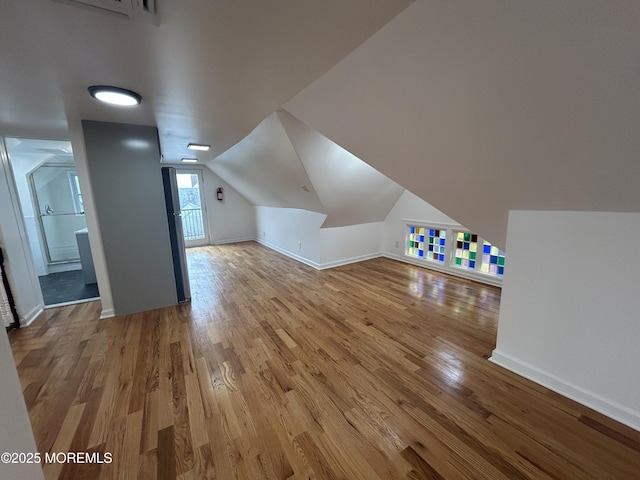 bonus room featuring baseboards, wood finished floors, and lofted ceiling