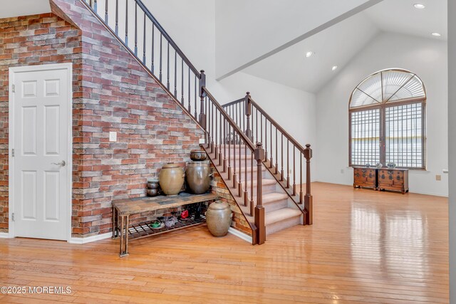 1 Kushnetki Rd, Parlin, NJ 08859 - stairway with recessed lighting, brick wall, high vaulted ceiling, and hardwood / wood-style flooring