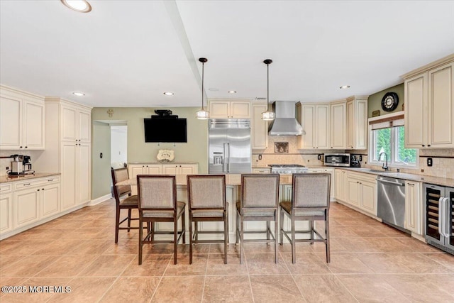 77 Warren Dr, Aberdeen, NJ 07747 - kitchen featuring cream cabinets, stainless steel appliances, wall chimney exhaust hood, a sink, and backsplash