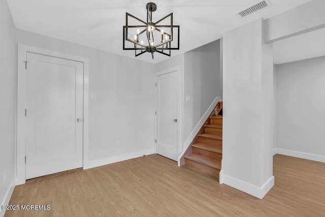 unfurnished dining area with light wood-style floors, stairway, visible vents, and an inviting chandelier