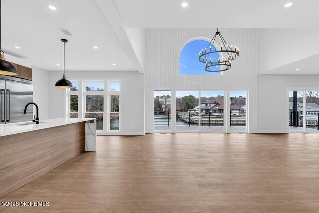 interior space featuring a chandelier, built in fridge, modern cabinets, and a sink