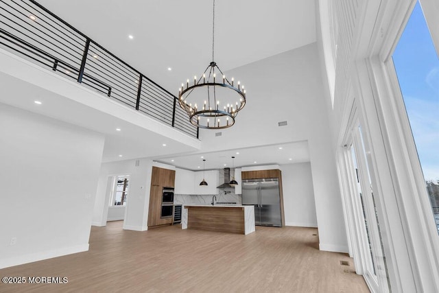 unfurnished living room featuring recessed lighting, light wood-type flooring, and baseboards