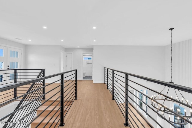 hallway with recessed lighting, an upstairs landing, light wood-style flooring, and baseboards