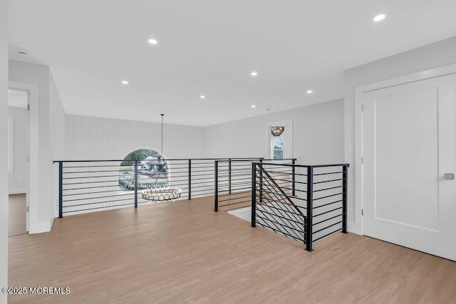 unfurnished room with wood finished floors, recessed lighting, a notable chandelier, and a healthy amount of sunlight