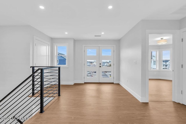 hall with recessed lighting, baseboards, an upstairs landing, and wood finished floors