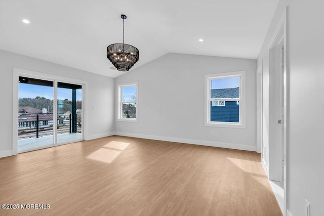 unfurnished room with a notable chandelier, light wood-style floors, baseboards, and lofted ceiling