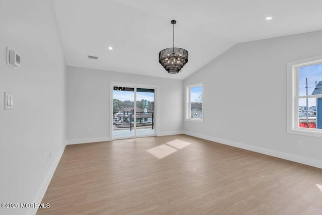 unfurnished room featuring light wood-style flooring, lofted ceiling, and a healthy amount of sunlight