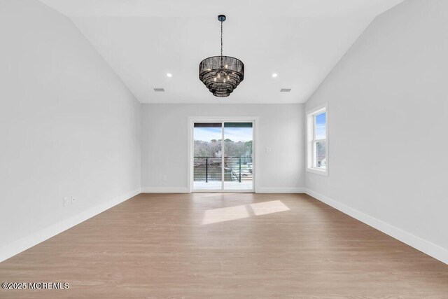 unfurnished room featuring a chandelier, baseboards, visible vents, and light wood-style flooring