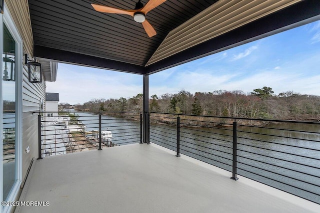 balcony with a water view and a ceiling fan
