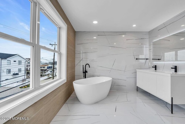 bathroom with vanity, tile walls, recessed lighting, a freestanding bath, and marble finish floor