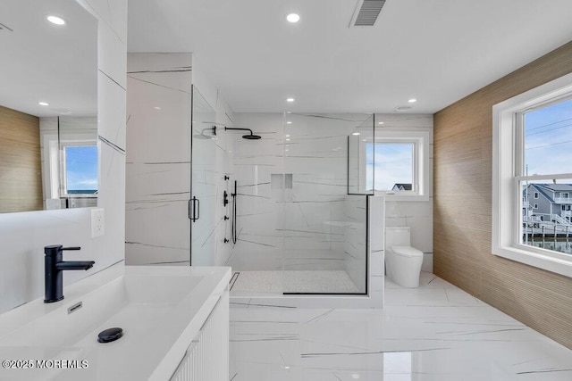 bathroom with visible vents, toilet, recessed lighting, a marble finish shower, and marble finish floor