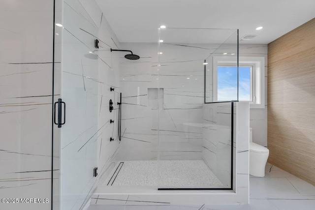 bathroom featuring a marble finish shower and toilet