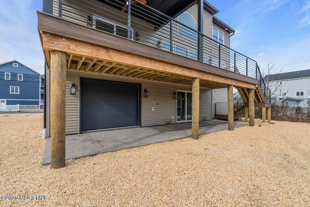 view of front of home with a garage, stairs, and a patio