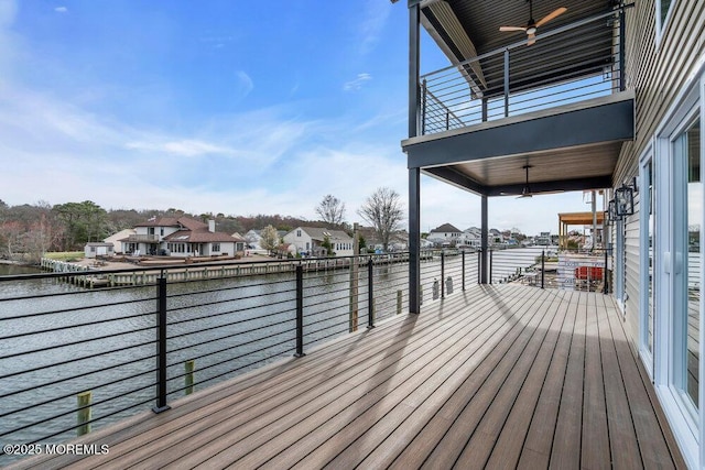 wooden terrace with a water view, a residential view, and ceiling fan
