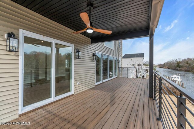 wooden terrace featuring a water view and a ceiling fan