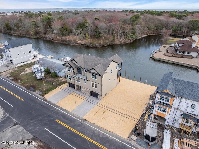 drone / aerial view with a forest view and a water view