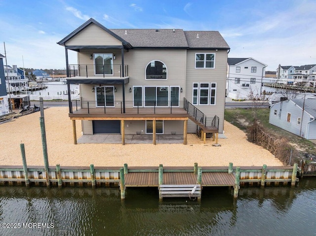 back of house featuring a deck with water view, a patio, and a balcony
