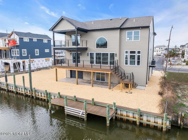 back of property with a patio area, stairs, a deck with water view, and a balcony