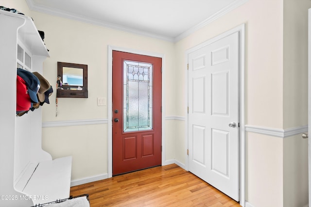 foyer entrance featuring light wood-style floors, baseboards, and crown molding