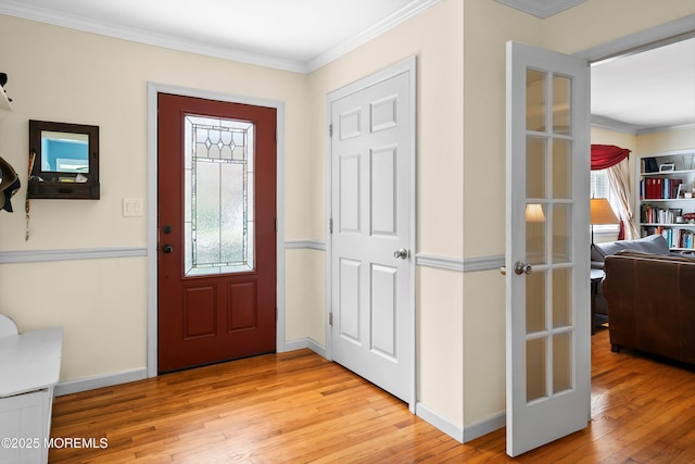 foyer entrance with crown molding, baseboards, and light wood-type flooring