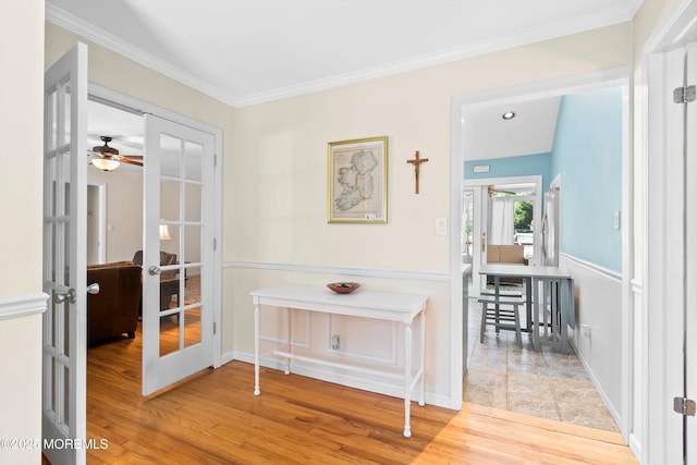 hallway featuring french doors, crown molding, and wood finished floors