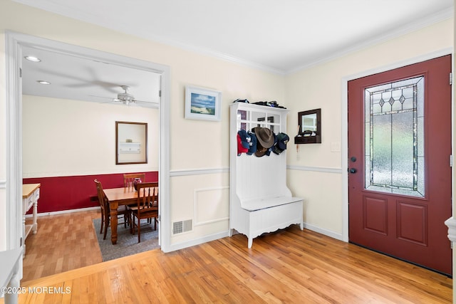 entrance foyer featuring visible vents, crown molding, ceiling fan, and light wood-type flooring