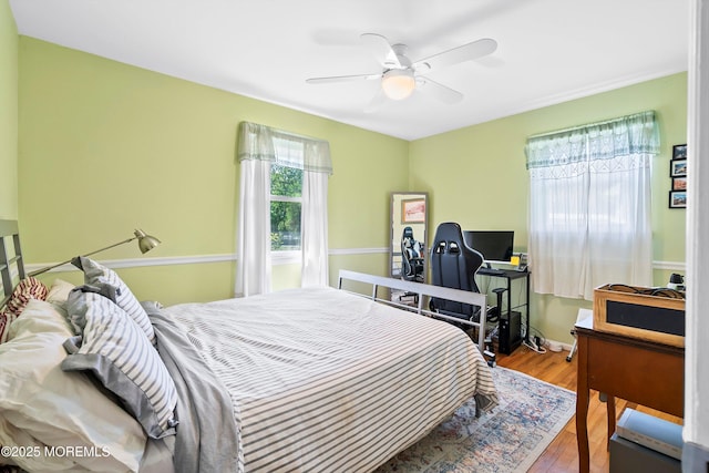 bedroom with baseboards, ceiling fan, and wood finished floors