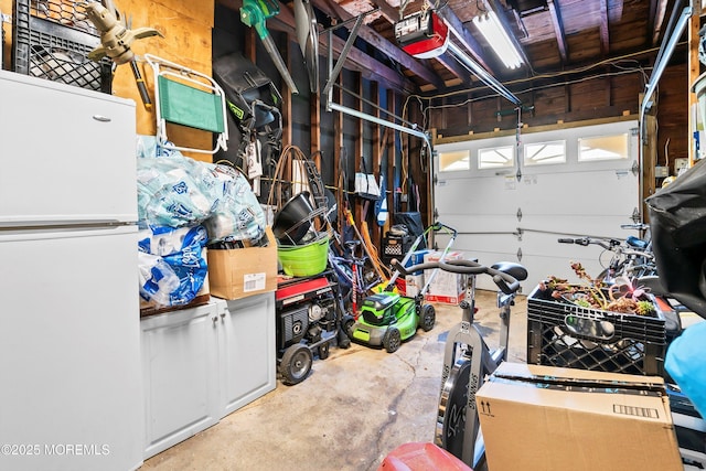 garage featuring freestanding refrigerator and a garage door opener