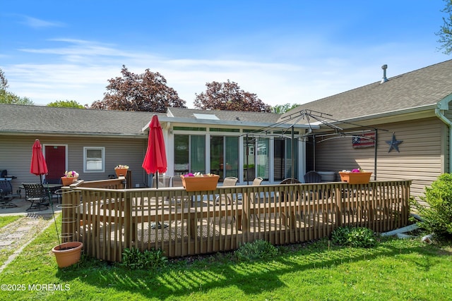 back of property with a shingled roof, outdoor dining area, a yard, and a deck