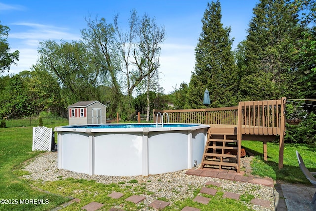 pool featuring a yard, a wooden deck, an outbuilding, and a shed