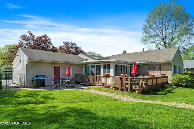 back of house with a lawn, a patio, a gate, and a sunroom